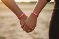 Close-up of couple's hands with God Knows Wristbands